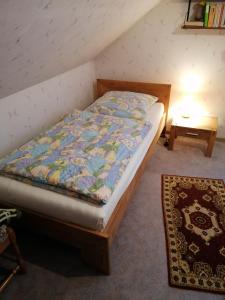 a bedroom with a bed and a table and a rug at Ferienwohnung Wiesenweg in Bad Bederkesa