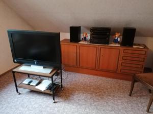 a living room with a flat screen tv on a dresser at Ferienwohnung Wiesenweg in Bad Bederkesa