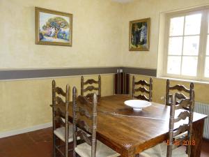 a dining room with a wooden table and chairs at Les Gîtes du Mont Suzey in Yvoy-le-Marron
