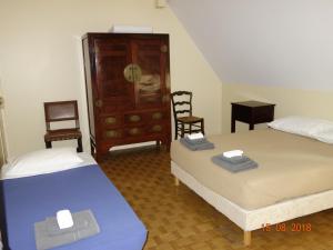 a room with two beds and a dresser and two chairs at Les Gîtes du Mont Suzey in Yvoy-le-Marron