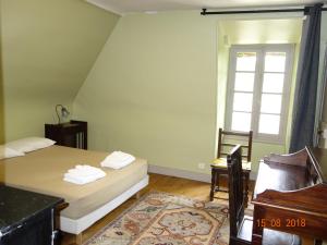 a bedroom with a bed and a chair and a window at Les Gîtes du Mont Suzey in Yvoy-le-Marron +6 photos