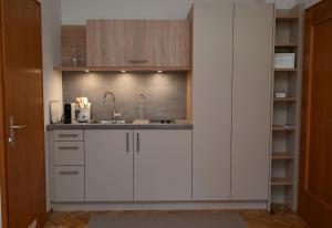 a kitchen with white cabinets and a sink at Villa Berginz by Seebnb in Velden am Wörthersee