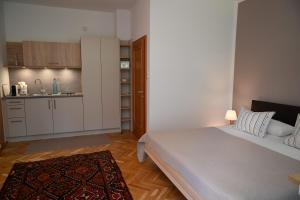 een kleine slaapkamer met een bed en een keuken bij Villa Berginz by Seebnb in Velden am Wörthersee