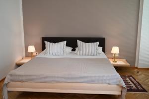a bedroom with a large bed with two lamps at Villa Berginz by Seebnb in Velden am Wörthersee