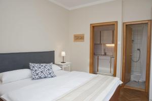 1 dormitorio con 1 cama blanca grande y baño en Villa Berginz by Seebnb, en Velden am Wörthersee