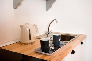 a kitchen counter with two cups on a tray next to a sink at El Nogal Home in Málaga