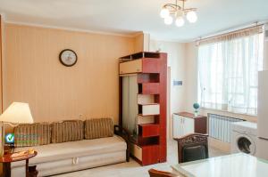 een woonkamer met een bank en een klok aan de muur bij Апартаменти на Новоолександрівській in Charkov
