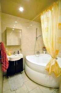 een badkamer met een groot bad en een wastafel bij Апартаменти на Новоолександрівській in Charkov