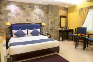 a bedroom with a king sized bed and a bathroom at Hotel Valley Garden in Sylhet