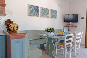 uma cozinha com uma mesa com cadeiras e uma televisão em La Terrazza - Splendido trilocale a Lacona em Lacona