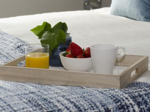 a tray with a plate of strawberries and a cup of orange juice at Sitges Spaces Sea View Paradise- 2 Bedrooms, 2 Bathrooms, Terrace, Amazing Sea Views in Sitges