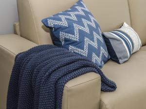 a blue blanket sitting on a couch with pillows at Sitges Spaces Sea View Paradise 5 min from Balmins in Sitges