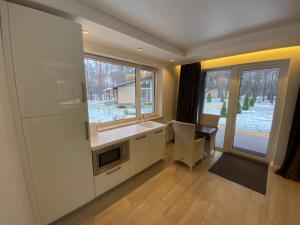 a kitchen with a sink and a table and a window at Park-Hotel Tihiy Les in Prokhorovka