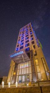 un edificio alto con un cartel en él por la noche en Grand Plaza Hotel - KAFD Riyadh en Riad