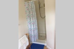 łazienka z zasłoną prysznicową i wanną w obiekcie Okewoon Farm w mieście Lanivet