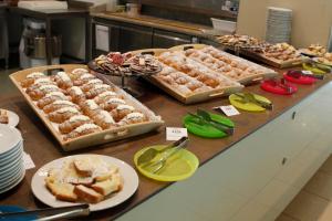 ein Buffet mit mehreren Tabletts mit Essen auf einem Tisch in der Unterkunft Hotel Mediterraneo in Montesilvano