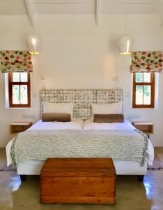 a bedroom with a large bed and two windows at Darling Lodge Guest House in Darling