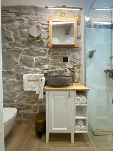 a bathroom with a sink and a stone wall at La Corte di Kate in Biograd na Moru