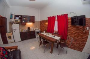 cocina con mesa de madera y cocina con cortinas rojas en Mio Amore Tigre - B en Tigre