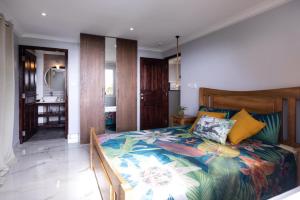 Un dormitorio con una cama con una colcha colorida. en Peponi SelfCatering Apartments, en Beau Vallon 9 fotos más