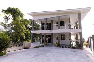 uma grande casa branca com uma grande entrada em Peponi SelfCatering Apartments em Beau Vallon