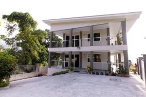 a large white house with a large driveway at Peponi SelfCatering Apartments in Beau Vallon