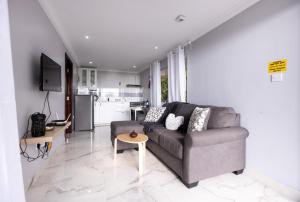 a living room with a couch and a kitchen at Peponi SelfCatering Apartments in Beau Vallon