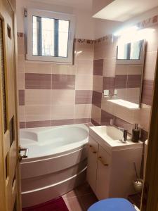 a bathroom with a tub and a sink at Mountain Loft in Piatra Neamţ