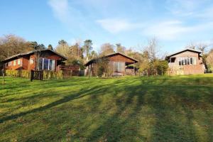 a large yard with two cottages in the background at Luxurious lodge, Hot tub at Rudyard Lake, couples or small family in Rudyard