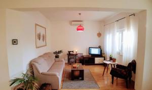 a living room with a couch and a tv at Spacious garden house, Orebić (4+1) in Orebić