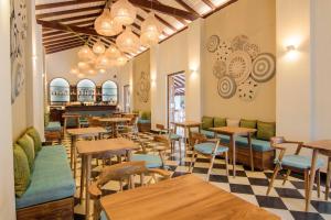 a restaurant with tables and chairs and a checkered floor at The Merchant in Galle