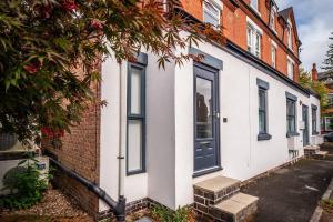 a white house with a black door on a street at Lady Bay Apartments in Nottingham