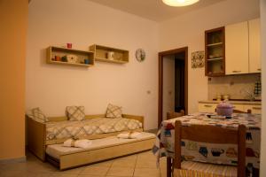 un soggiorno con letto e tavolo e una cucina di Casa Mare Naxos Flat - Home Holiday a Giardini Naxos Altre 8 foto