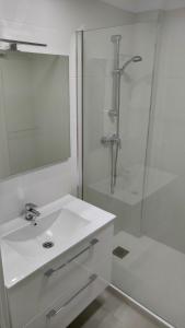 een witte badkamer met een wastafel en een douche bij VERDEMAR 16 MENYBER in Nerja