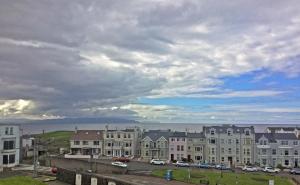 a group of buildings in a city under a cloudy sky at The Gateway Guest Apartment in Portstewart