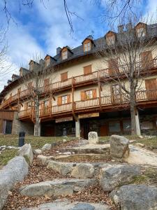 un grande edificio in legno con alberi di fronte di Apartamentos La Solana a Pla de l'Ermita