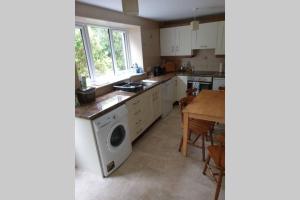 a kitchen with a washing machine and a table at 2 bed house at Ballycastle seafront in Ballycastle +4 photos