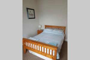 a bedroom with a wooden bed in a room at 2 bed house at Ballycastle seafront in Ballycastle