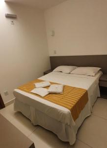 a bedroom with a large bed with towels on it at Hotel Hellyus in Brasilia