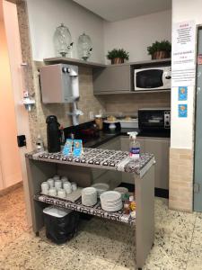 una cocina con encimera con platos. en Hotel Hellyus en Brasilia