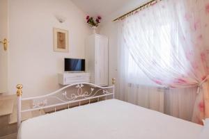 - une chambre avec un lit blanc et une télévision dans l'établissement Villa Agape, à Mirce