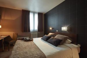 a hotel room with a bed and a nightstand at Ashley Hôtel Le Mans Centre Gare in Le Mans
