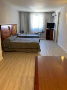 um quarto de hotel com uma cama e uma televisão em Cristal Palace Hotel em Buenos Aires