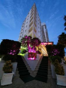 un bâtiment avec un escalier en face de celui-ci et des lumières violettes dans l'établissement Hotel Arvi, à Durrës