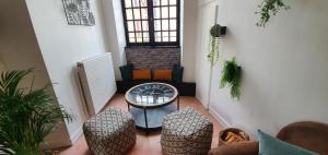 uma sala de estar com uma mesa e dois bancos em Appartement Duplex au Coeur du Centre Historique em Bergerac