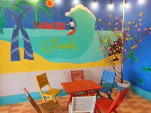 a table and chairs in a room with a mural at Homestay Nam Du Xanh in Nam Du