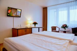 ein Hotelzimmer mit 2 Betten und einem Fenster in der Unterkunft Comfort Hotel Bernau in Bernau bei Berlin