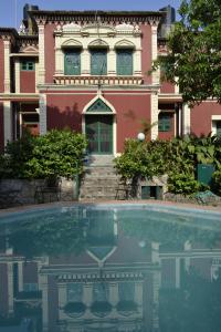 een huis met een zwembad voor een gebouw bij WelcomHeritage Judges Court in Kangra