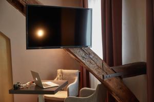 a desk with a chair and a tv on it at Ashley Hôtel Le Mans Centre Gare in Le Mans