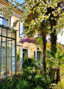 a house with a tree with flowers in front of it at Maison Saint James in Montélimar